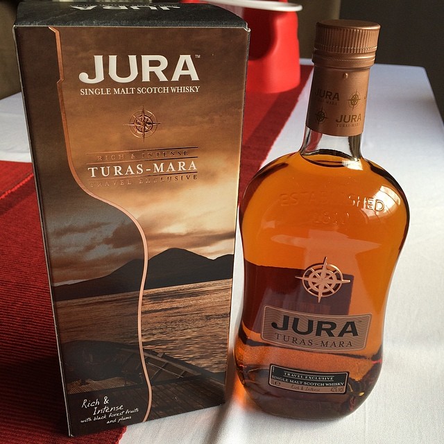 Box and bottle of Jura Turas-Mara single malt Scotch whisky on a table, with amber liquid visible in the bottle.