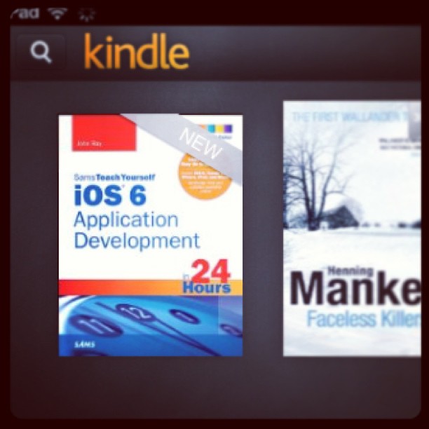 Kindle app screen showing a bookshelf with book covers, including “iOS 6 Application Development in 24 Hours” and a partially visible second book.