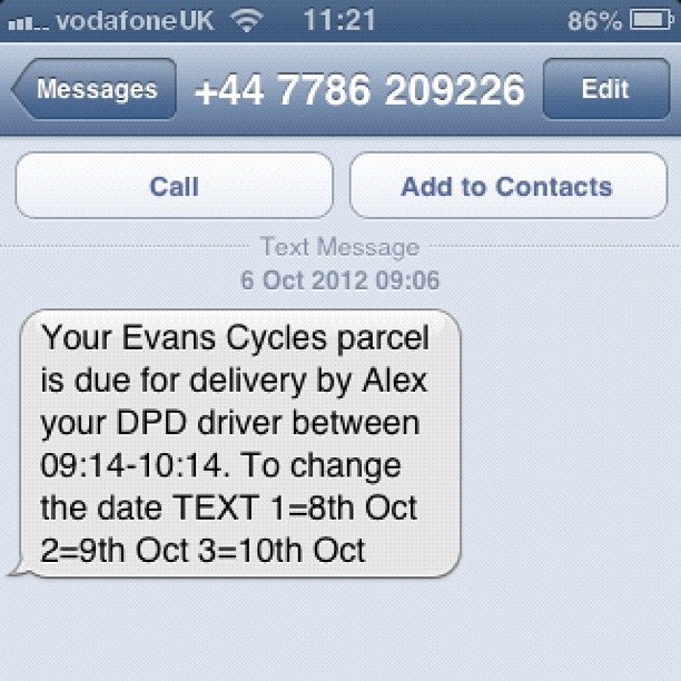 Phone screen showing a text saying an Evans Cycles parcel will be delivered by Alex between 09:14 and 10:14, with options to change the date.
