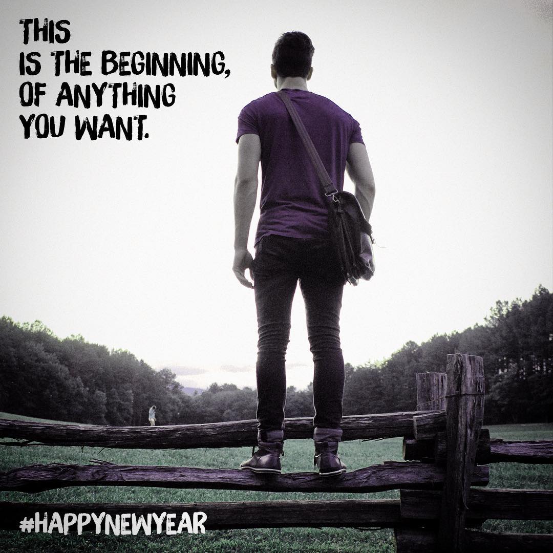 Person standing on a wooden fence facing a field and trees, with text reading, "This is the beginning, of anything you want. #HappyNewYear