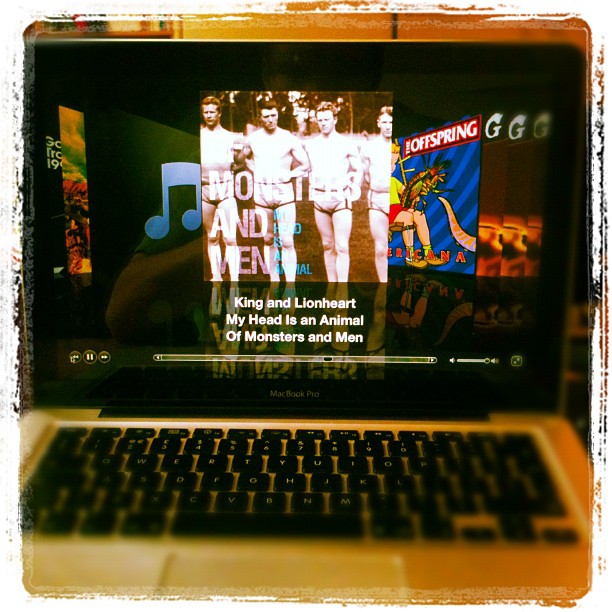 MacBook Pro screen showing a music player with album art and the text "King and Lionheart" by Of Monsters and Men.