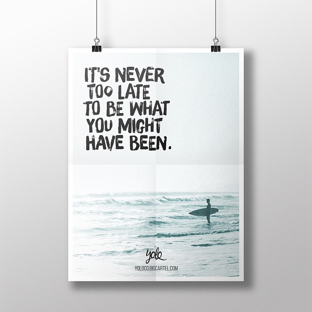 Poster clipped to a wall with the quote “It’s never too late to be what you might have been” above a surfer standing in the ocean.