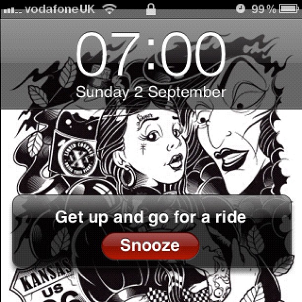 Phone alarm screen at 07:00 on Sunday 2 September with a black-and-white illustrated background and buttons for ride reminder and snooze.