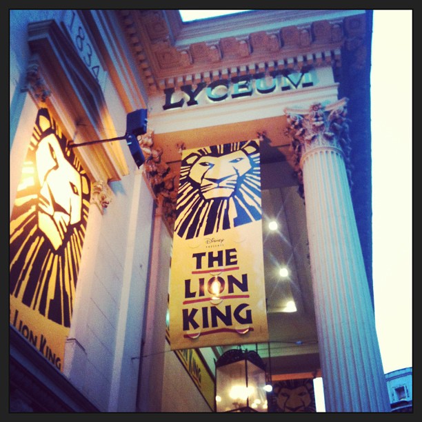 The Lion King banners hanging on the columned entrance of the Lyceum Theatre.
