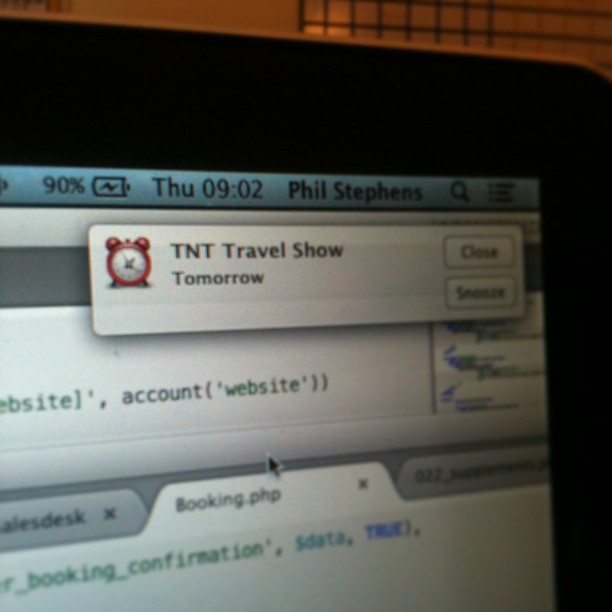 Computer screen showing a calendar reminder popup for “TNT Travel Show” scheduled for tomorrow.