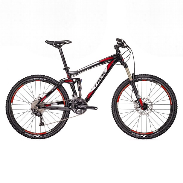Black and red full-suspension mountain bike with knobby tires and front suspension on a white background.