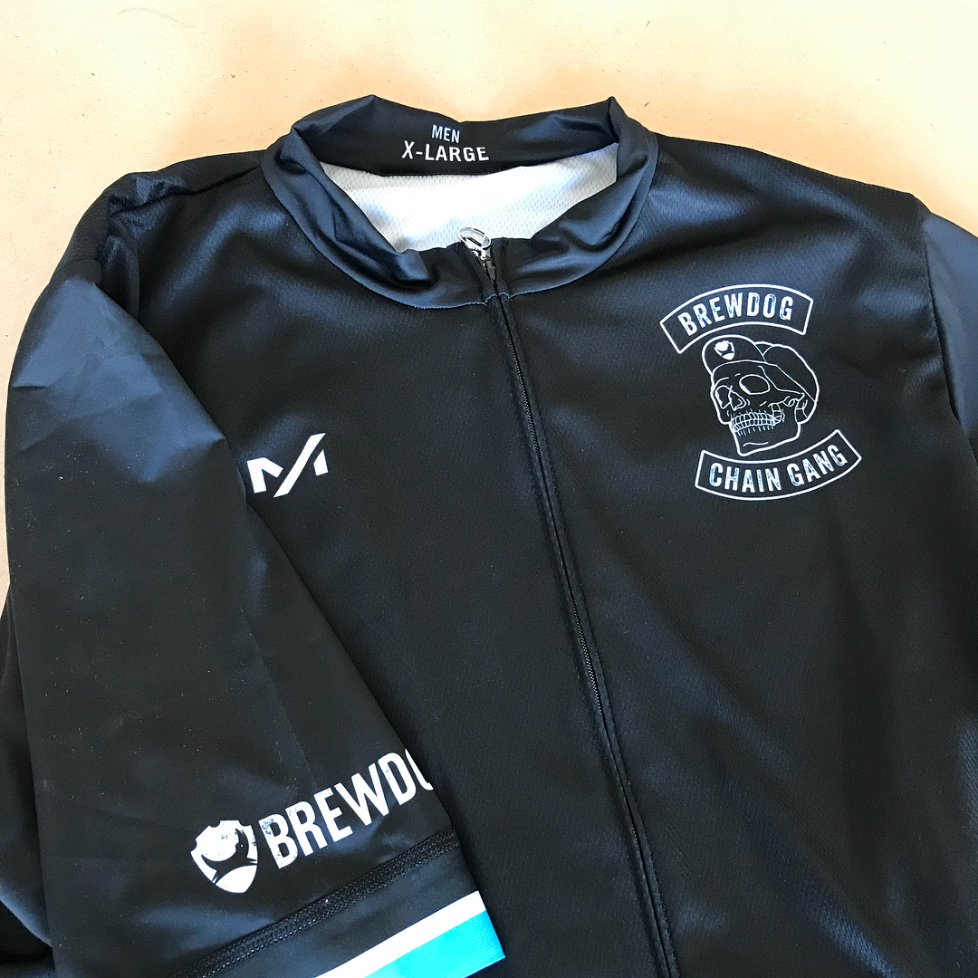 Black zip-up cycling jersey with BrewDog Chain Gang skull logo, BrewDog text on the sleeve, and Men X-Large printed inside the collar.