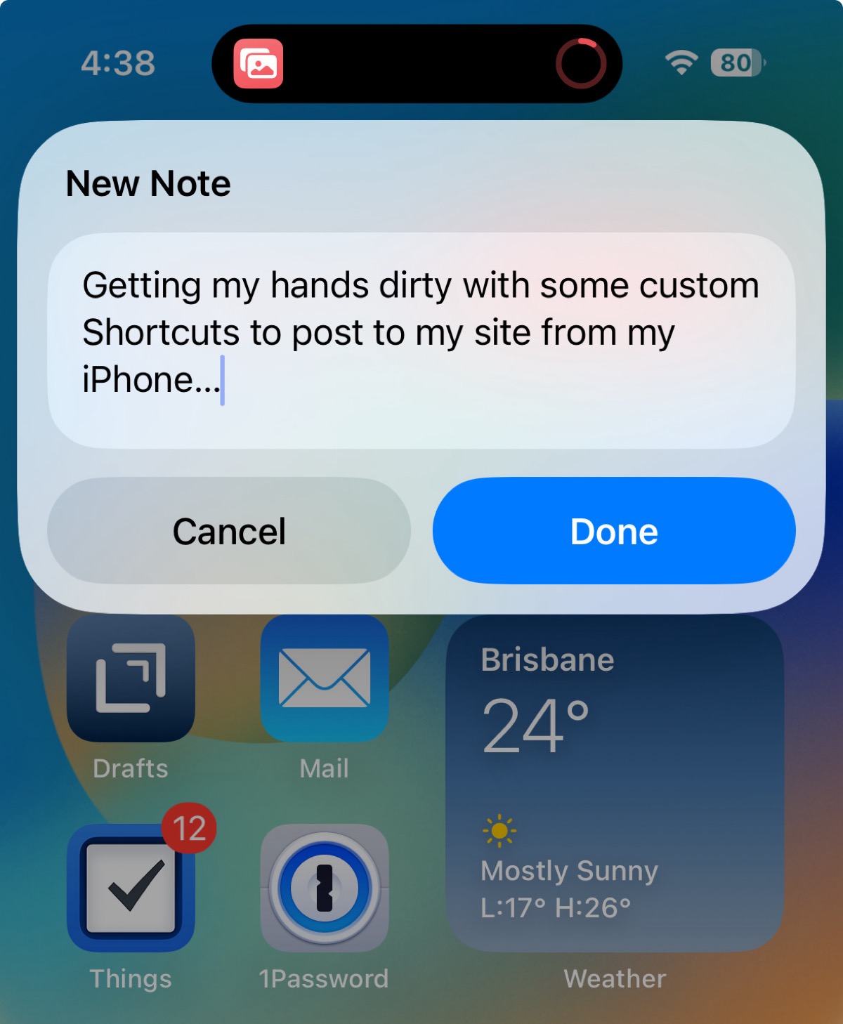 iPhone pop-up titled “New Note” with typed text, plus Cancel and Done buttons over the home screen.