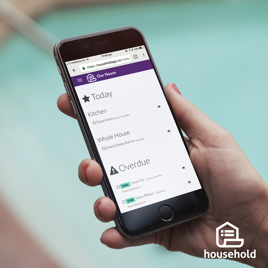 Hand holding a smartphone displaying a household chores app with today and overdue cleaning tasks on the screen.