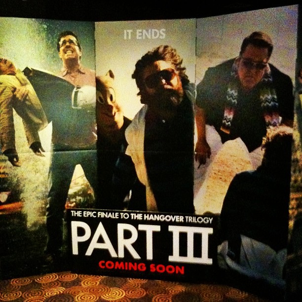 Promotional display for The Hangover Part III with three large character panels and the text "PART III COMING SOON" at the bottom.