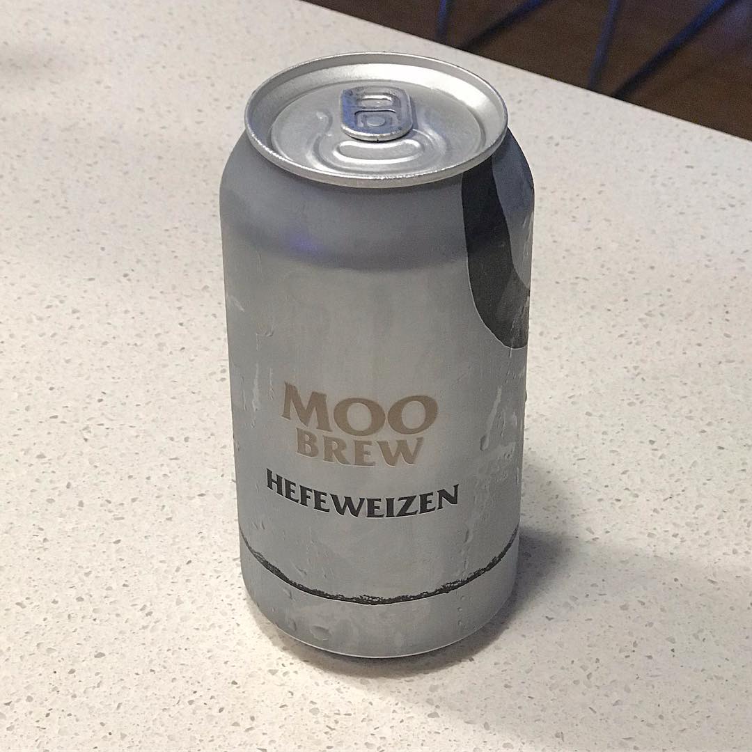 Silver can labeled “Moo Brew Hefeweizen” on a light speckled countertop.