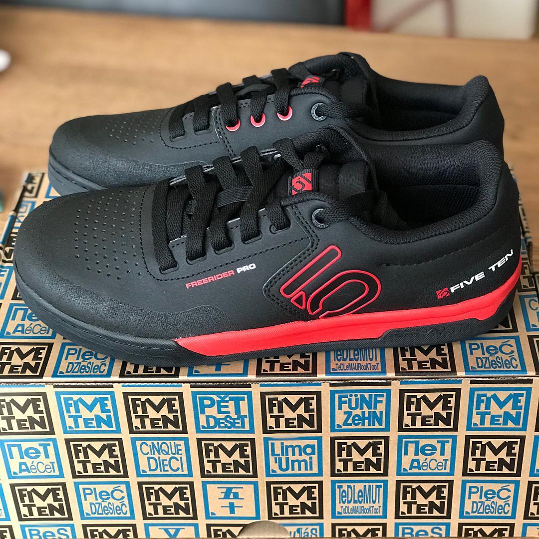 Pair of black Five Ten Freerider Pro sneakers with red accents on a patterned Five Ten shoe box.