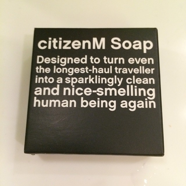 Black soap box labeled “citizenM Soap” with white text about turning a long-haul traveler into a clean, nice-smelling human again.