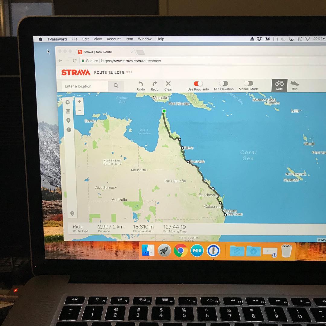 Laptop screen showing Strava Route Builder with a cycling route mapped down Australia's east coast from Cape York to the Gold Coast.