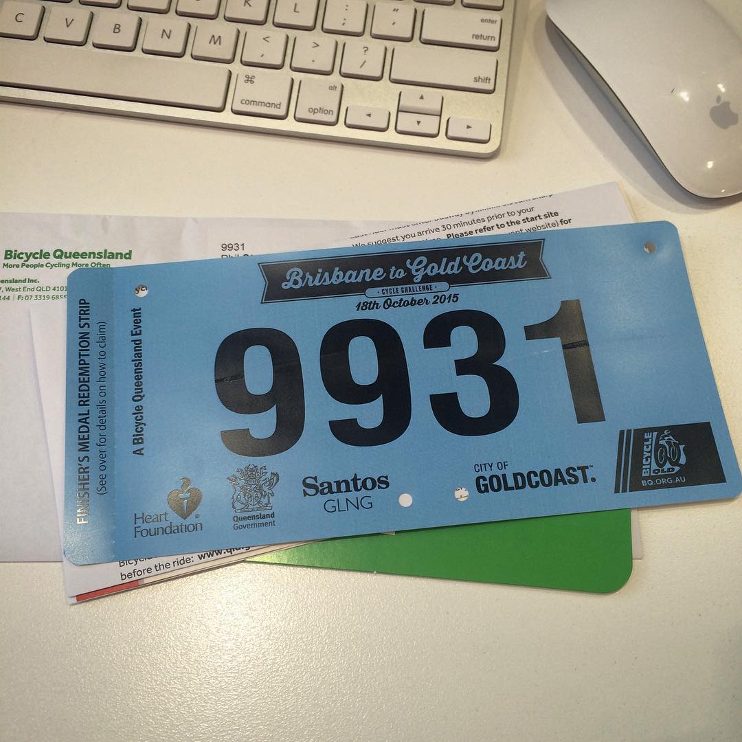 Blue Brisbane to Gold Coast cycling event bib numbered 9931 on a desk beside a keyboard and mouse.