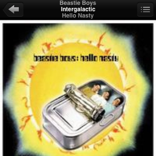 Album art on a music player screen showing a tin can with three people inside against a glowing yellow background.
